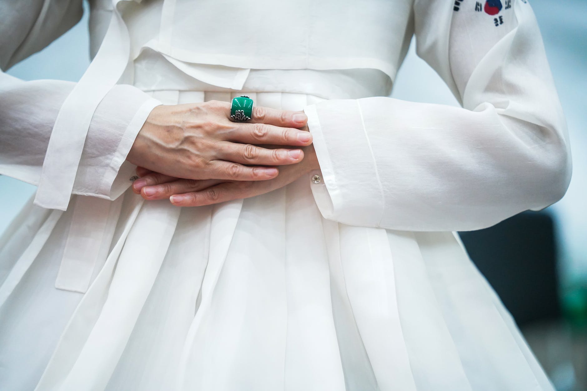 a woman in a white hanbok wearing an emerald ring